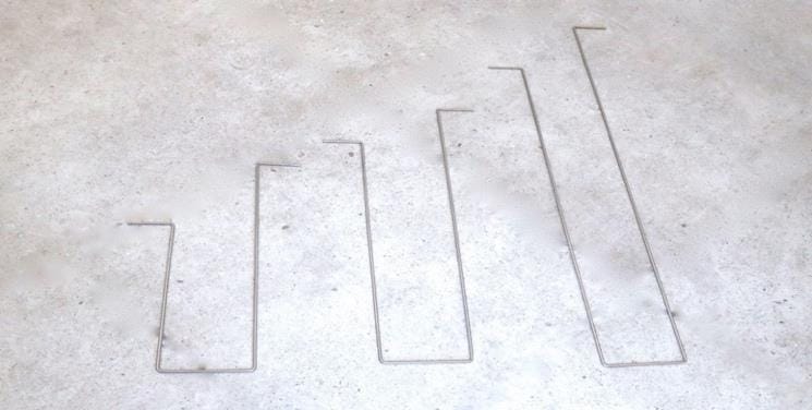 Stainless side picks in three sizes laid out on concrete